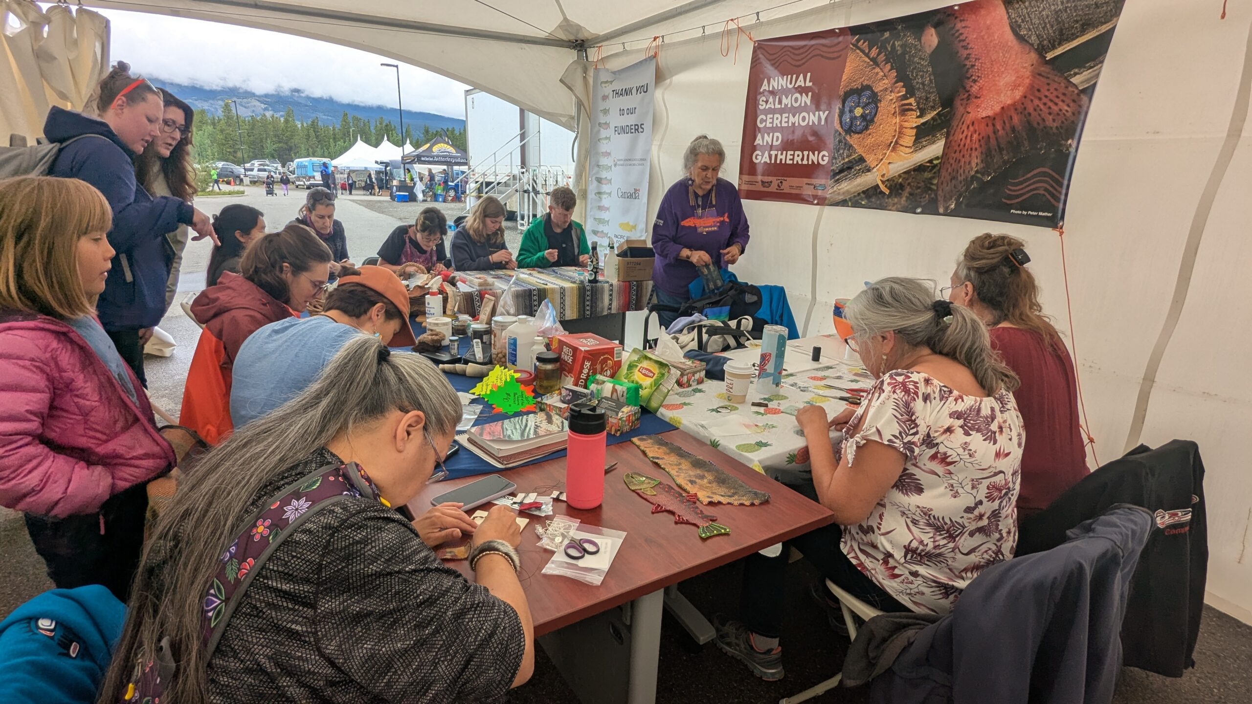 Image of Elders, Youth and community members beading together at the Annual Salmon Ceremony and Gathering.